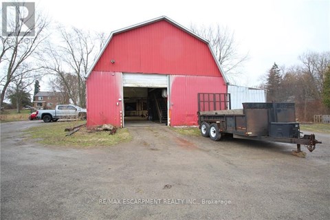 A red barn with a truck parked in front of it.
