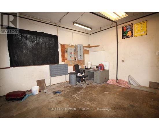 A room with a lot of debris and a fan on the floor.