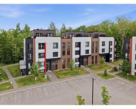 Apartment complex with a parking lot in front.