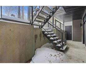 A staircase with a metal railing is covered in snow.