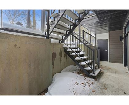 A staircase with a metal railing is covered in snow.