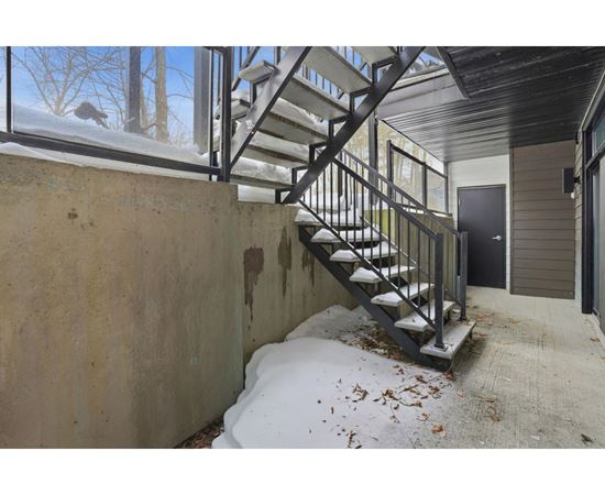 A staircase with a metal railing is covered in snow.