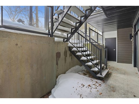 A staircase with a metal railing is covered in snow.