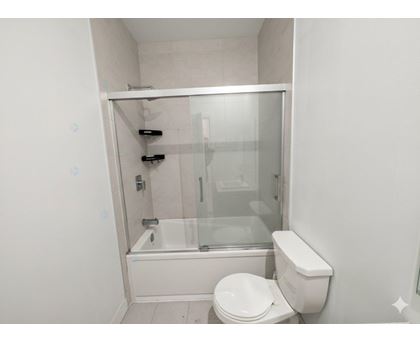A white toilet sits next to a glass shower stall.