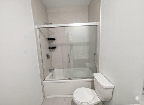 A white toilet sits next to a glass shower stall.