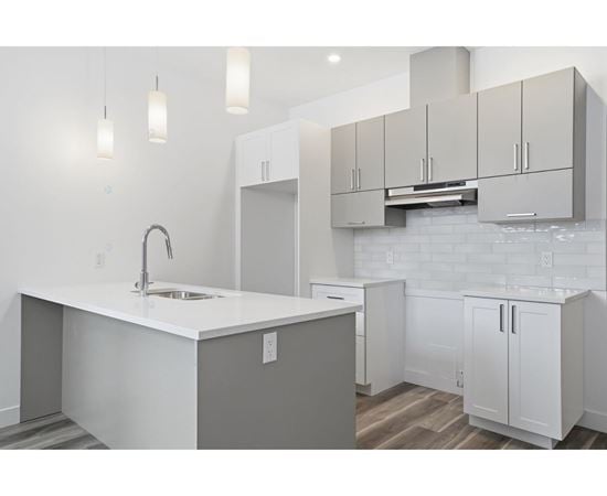 A kitchen with white cabinets and a white countertop.