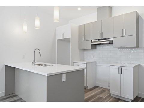 A kitchen with white cabinets and a white countertop.