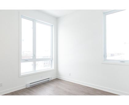 A room with a window and a wall-mounted air conditioner.