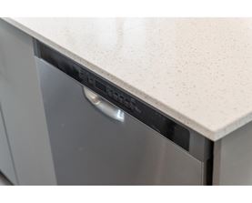 A dishwasher with a silver handle and a white countertop.
