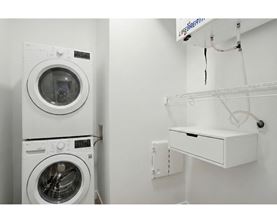A white washing machine and dryer in a small laundry room.