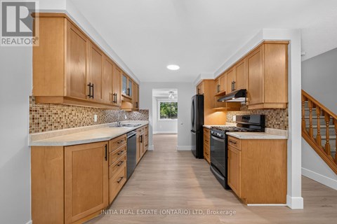 A kitchen with wooden cabinets and a black stove top oven.