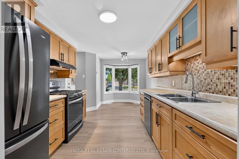 A kitchen with wooden cabinets and a black refrigerator.
