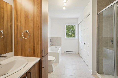 A bathroom with a white toilet and a glass shower stall.