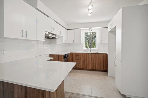 A kitchen with white cabinets and a countertop.