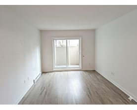 A room with a large window and wooden flooring.