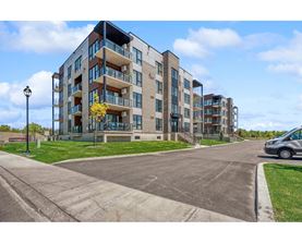 A modern apartment building with a parking lot in front.