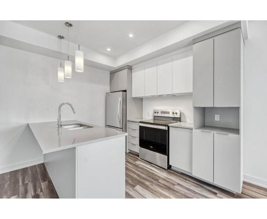 A modern kitchen with white cabinets and stainless steel appliances.
