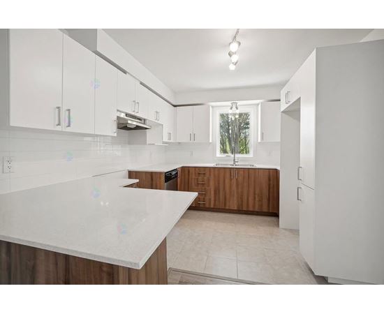 A kitchen with white cabinets and a white countertop.