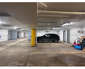 A black car is parked in a parking garage.