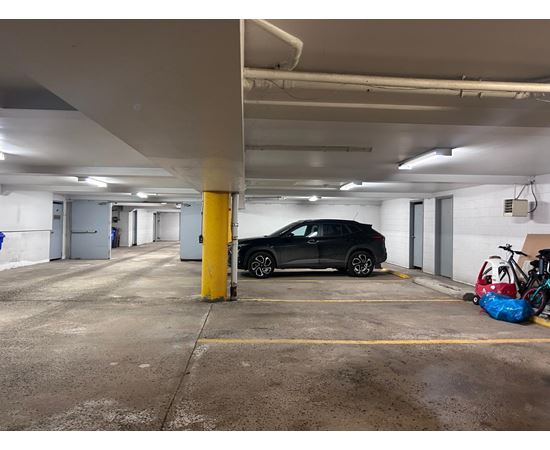 A black car is parked in a parking garage.