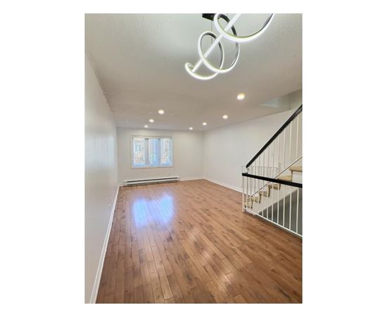 A room with wooden floors and a staircase.