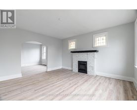 A white room with a fireplace and two windows.