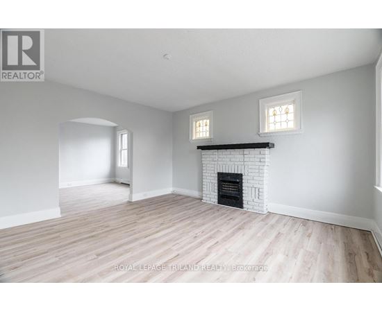 A white room with a fireplace and two windows.