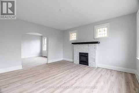 A white room with a fireplace and two windows.