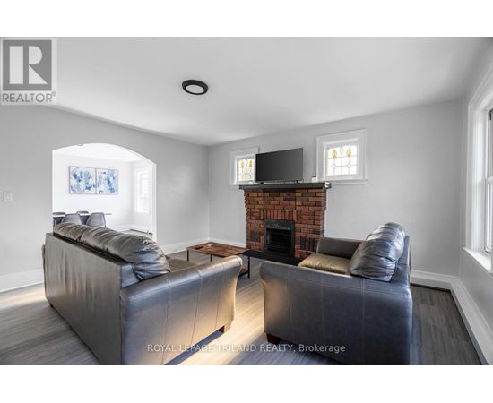 A living room with a grey couch and a fireplace.