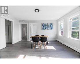 A dining room with a table and chairs.
