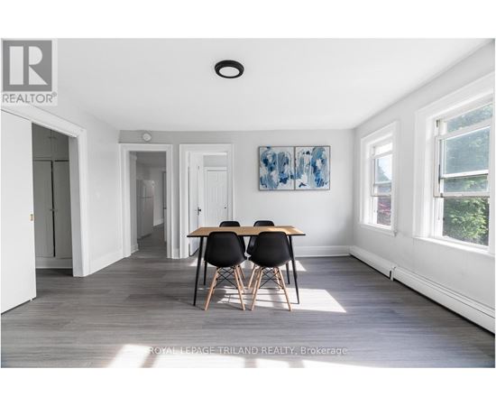 A dining room with a table and chairs.