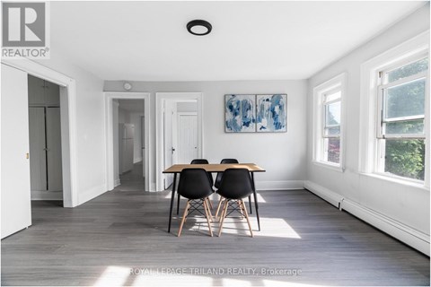 A dining room with a table and chairs.