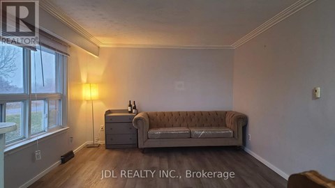 A living room with a brown couch and a lamp.
