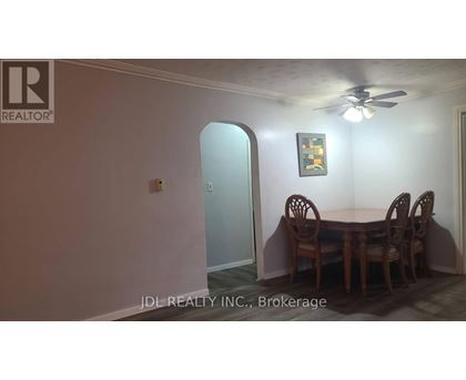 A dining room with a table and chairs.