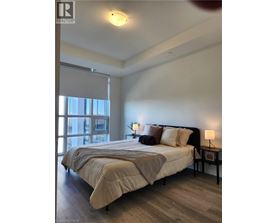 A bedroom with a large bed and a window with blinds.