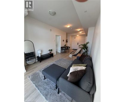 A living room with a grey couch and a grey rug.