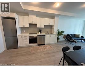 A kitchen with white cabinets and a refrigerator.