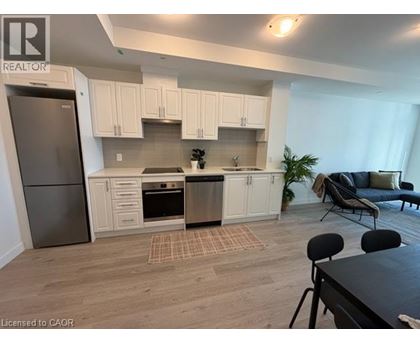 A kitchen with white cabinets and a refrigerator.