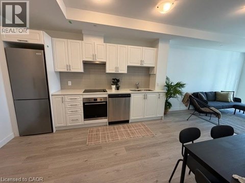 A kitchen with white cabinets and a refrigerator.