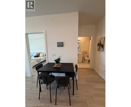 A dining room with a table and chairs.