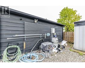 A shed with a pool pump and hoses outside.