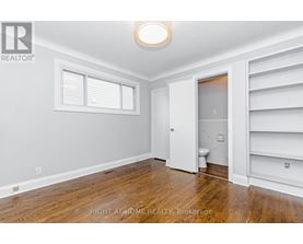 A room with a toilet and a door leading to another room.