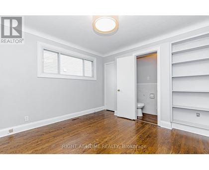 A room with a toilet and a door leading to another room.