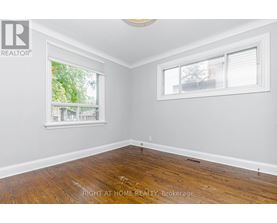 A room with a window and wooden flooring.