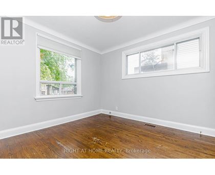 A room with a window and wooden flooring.