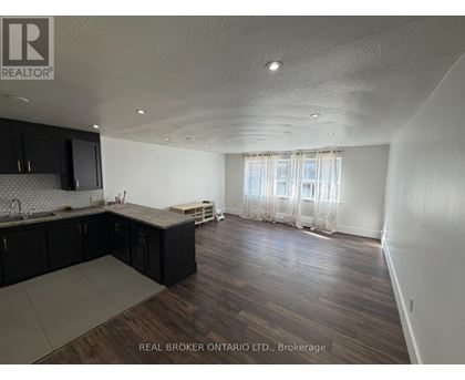 A spacious kitchen with dark wood cabinets and a countertop.
