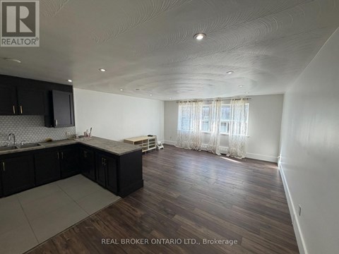 A spacious kitchen with dark wood cabinets and a countertop.