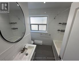 A bathroom with a sink, mirror, and bathtub.