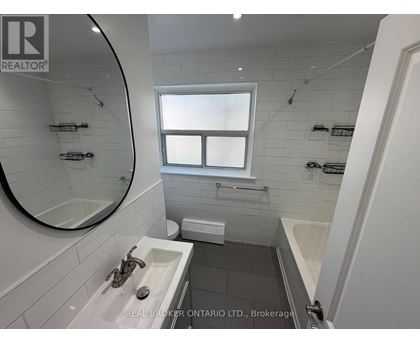 A bathroom with a sink, mirror, and bathtub.