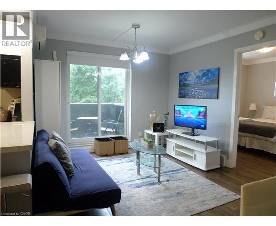 A living room with a blue couch and a television on a white stand.